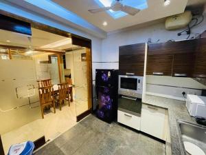 a kitchen with a sink and a table with a microwave at Divine India Service Apartment 4Bhk D-163 Saket in New Delhi