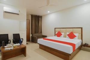 a hotel room with a bed and a desk and chair at Hotel Golfview in Panchkula