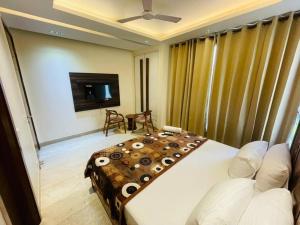 a bedroom with a large bed and a tv at Divine India Service Apartment 4Bhk D-163 Saket in New Delhi