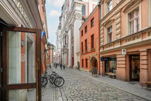 a street with bikes parked on a cobblestone street at Sunny Apartments in the Heart of Poznań Old Town by Renters in Poznań