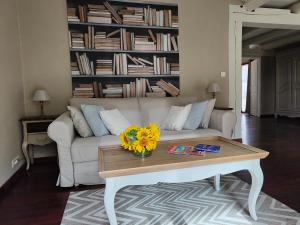 a living room with a white couch and a coffee table at Le Chant du Coeur in Roussillon