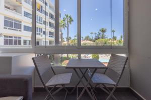 a table and chairs in a room with a window at Complejo Aloe - Pool - close to Maspalomas Beach in San Bartolomé de Tirajana