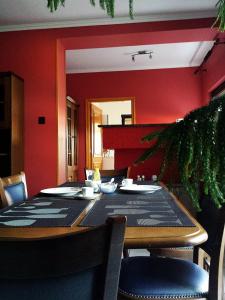 ein Esszimmer mit einem Tisch und roten Wänden in der Unterkunft Napfény villa in Balatonfüred