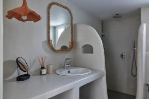 ein weißes Badezimmer mit Waschbecken und Spiegel in der Unterkunft Iliana Olive Branch in Adamas