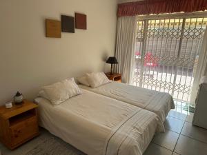 um quarto com uma cama e uma grande janela em Ipanema 2 em Margate