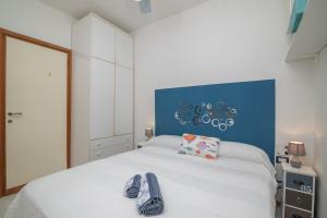una camera da letto con un letto bianco e scarpe sopra di Sardinia Paradise House - Happy Rentals a Marina di Portisco
