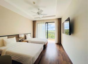 pokój hotelowy z 2 łóżkami i oknem w obiekcie Vinholidays Fiesta Phu Quoc w Duong Dong