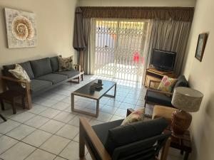 uma sala de estar com um sofá e uma mesa em Ipanema 2 em Margate