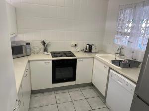 uma cozinha branca com um fogão e um lavatório em Ipanema 2 em Margate
