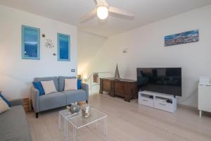ein Wohnzimmer mit einem Sofa und einem Flachbild-TV in der Unterkunft Sardinia Paradise House - Happy Rentals in Marina di Portisco