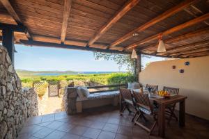 um pátio com uma mesa e cadeiras e uma vista em Sardinia Paradise House - Happy Rentals em Marina di Portisco