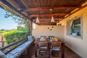 patio ze stołem, krzesłami i kanapą w obiekcie Sardinia Paradise House - Happy Rentals w mieście Marina di Portisco