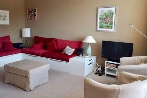 uma sala de estar com um sofá vermelho e uma televisão em L'Ariondaz - Appartement au centre du village, proche des pistes, avec parking em Courchevel
