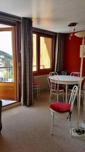 a dining room with a table and chairs and a window at L'Ariondaz - Appartement au centre du village, proche des pistes, avec parking in Courchevel