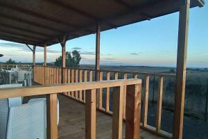a wooden deck with a view of the ocean at Agri Homes Spanora in Crocicchie