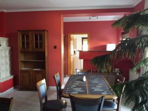 a dining room with a table and chairs and red walls at Napfény villa in Balatonfüred