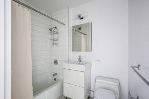 een witte badkamer met een toilet en een wastafel bij Midtown 2br w elevator wd nr entertainment NYC-1227 in New York +22 foto's
