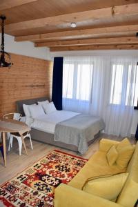 a bedroom with a bed and a couch and a table at Happy Holidays Apartments in New Gudauri in Gudauri