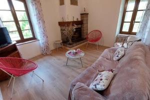 Gîte pour 6 pers avec jardin clos proche Aurillac : غرفة معيشة مع أريكة ومدفأة