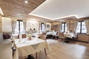 a restaurant with white tables and chairs and windows at Hotel Sonne in Brand