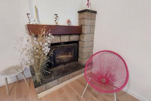chimenea con ventilador rojo y silla en Gîte pour 6 pers avec jardin clos proche Aurillac, 