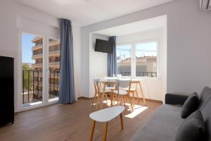 a living room with a table and chairs and a couch at Apartamento Santa Maria by Be Alicante in Alicante