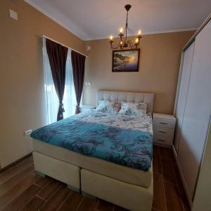 Schlafzimmer mit einem Bett und einem Kronleuchter in der Unterkunft Villa sv.Petka-Ohrid in Ohrid