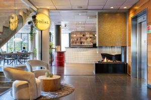 a lobby with a fireplace and chairs and a table at Clarion Hotel Stavanger in Stavanger