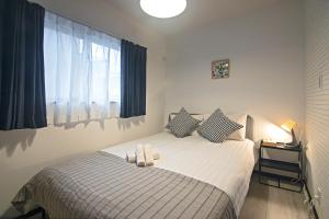 een slaapkamer met een bed met twee kussens en een raam bij -旅タイム 玉出東- 岸里玉出駅 in Osaka