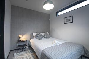 Een bed of bedden in een kamer bij -旅タイム 玉出東- 岸里玉出駅