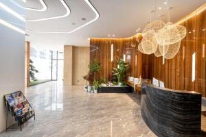 a lobby with a wooden wall and a chandelier at Vizhanwan Hotel Shenzhen International Convention and Exhibition Center in Shenzhen