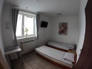 - une petite chambre avec un lit et une fenêtre dans l'établissement noclegi u Adama, à Kajetany