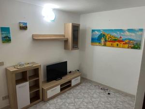 a living room with a tv on a wall at Casa Nannina in Ischia Town