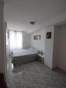 a white bedroom with a bed and a window at Casa Nannina in Ischia Town