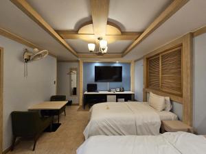 a hotel room with two beds and a desk at Hotel G7 Daejeon in Daejeon