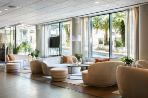 eine Lobby mit Sofas, Tischen und Fenstern in der Unterkunft Clarion Hotel Stavanger in Stavanger