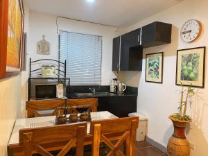 a kitchen with a table and chairs and a microwave at A nature’s den in Tagaytay in Tagaytay