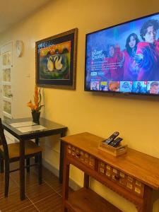 a room with a table and a tv on the wall at A nature’s den in Tagaytay in Tagaytay