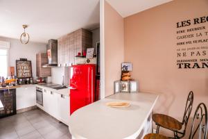 a kitchen with a red refrigerator and a table at Welcome Gigi's Room 1 in Châteaubourg