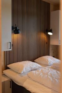 2 camas con sábanas blancas y almohadas en un dormitorio en Zicht op Twente - Spa lodges, en Markelo