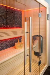 - un sauna avec du parquet et une porte en verre dans l'établissement Mooi Twente Lodges - privé Spa en sauna, à Markelo