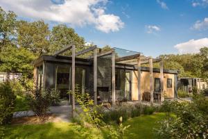 a house with a glass roof in a garden at Mooi Twente Lodges - privé Spa en sauna in Markelo