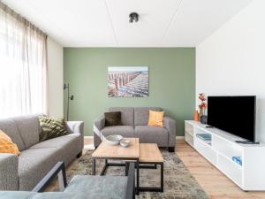 ein Wohnzimmer mit einem Sofa und einem TV in der Unterkunft Attractive holiday home in Scherpenisse with roofed terrace in Scherpenisse