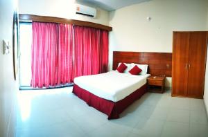 a bedroom with a bed with a red curtain at Castle Bay Touch Cox's Bazar in Cox's Bazar