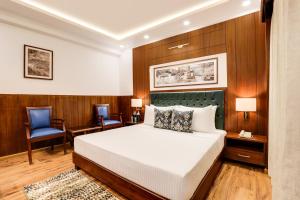 una camera da letto con un letto, una scrivania e una sedia di Lemon Tree Hotel, Mcleodganj a McLeod Ganj