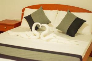 zwei Schwäne, die auf einem Bett in Handtücher gehauen wurden in der Unterkunft Owinro Beach Hotel & Restaurant - Waikkala in Kammala South