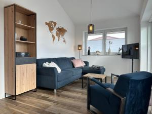 ヴァンガーラントにあるPenthouse Ahoi Hooksielの青いソファとテレビのあるリビングルーム