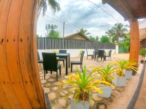 a patio with tables and chairs and plants at Owinro Beach Hotel & Restaurant - Waikkala in Kammala South