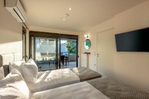 a bedroom with two beds and a flat screen tv at Dioni by PosarelliVillas in Kounoupidhianá