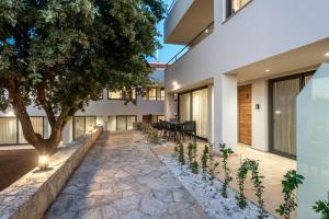 a courtyard of a house with a tree in the middle at Dioni by PosarelliVillas in Kounoupidhianá